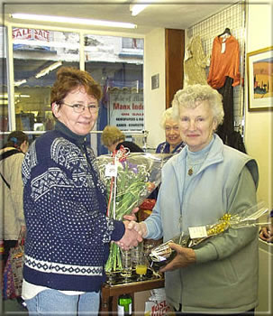 Marianne Smith of Danica Florists in Castletown presents Anne Clague with a bouquet and bottle of wine.